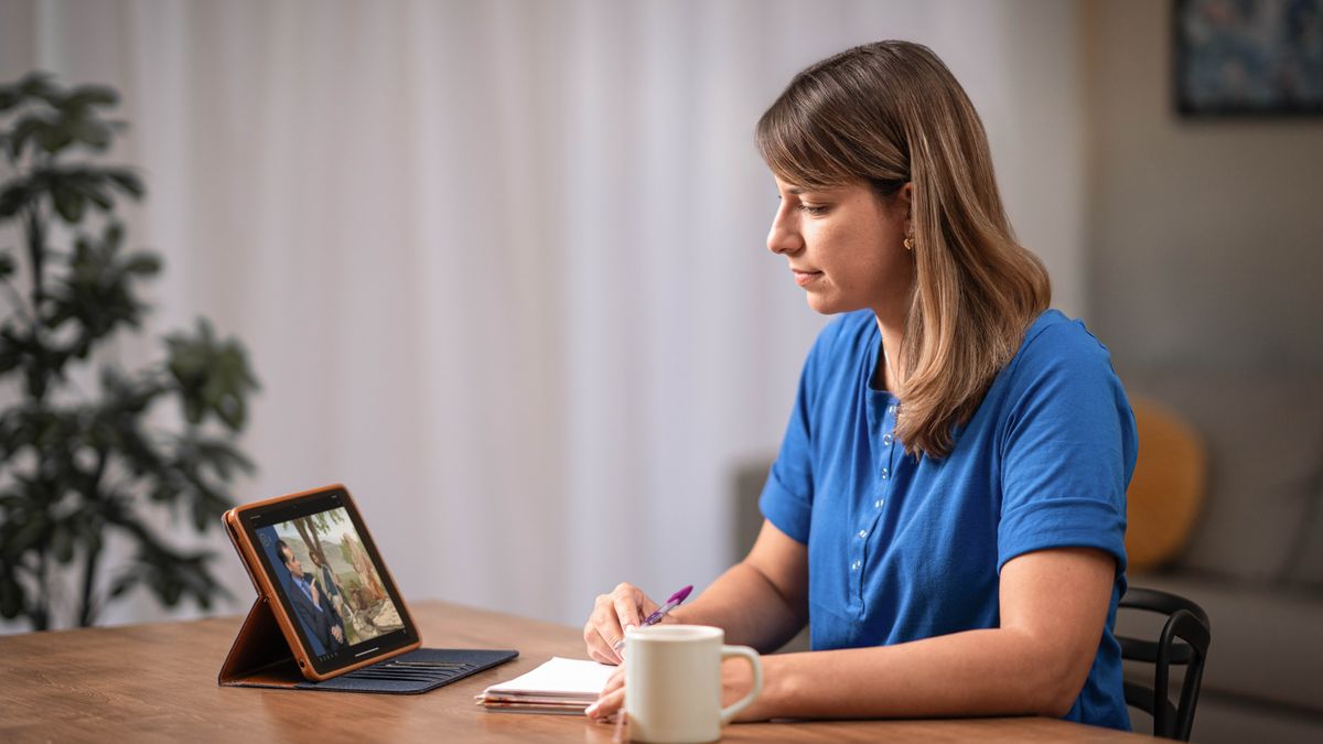 Siostra z poprzedniej ilustracji, która była zestresowana i spięta, siedzi w domu i czyta broszurę „Kochaj ludzi — pozyskuj uczniów”.