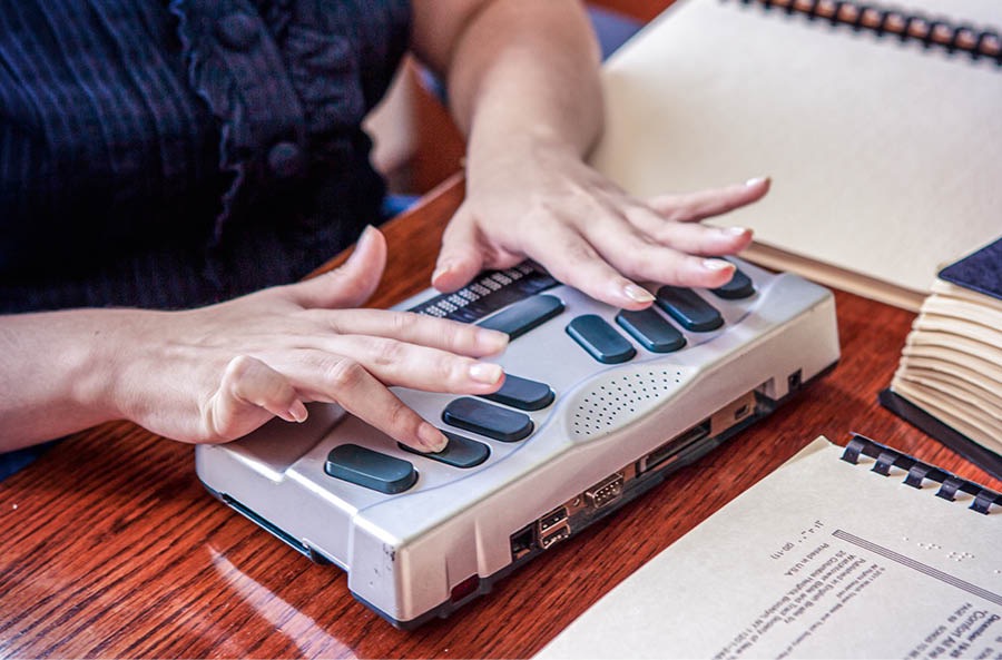 Collage: 1. A sister reading a braille publication. 2. A sister using a braille notetaker.