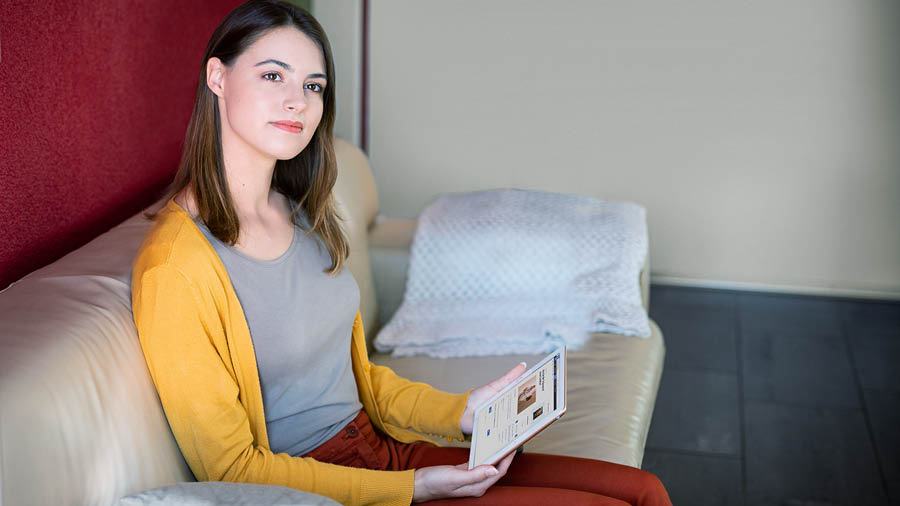 A irmã medita no que leu e consulta o livro ‘‘Dê Testemunho Cabal’ sobre o Reino de Deus’.