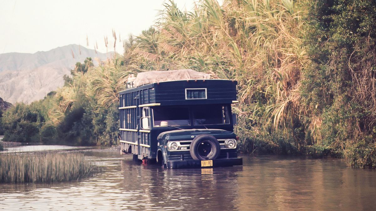 Uma caravana atravessa um terreno alagado.