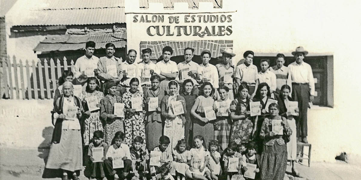 Um grupo de Testemunhas de Jeová segura exemplares da revista “A Sentinela”, em espanhol, em frente ao local onde se realizavam as reuniões, em 1952. A placa no edifício, em espanhol, diz: “Salão para Estudos Culturais”.