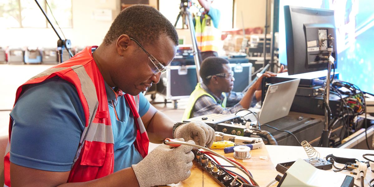 Dois irmãos a reparar um equipamento de áudio e vídeo.