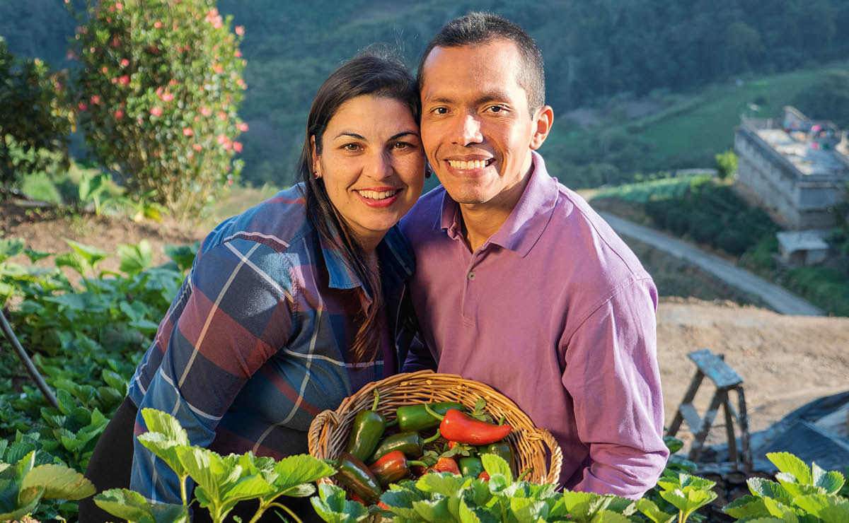Carmen e Edgar, com um cesto de pimentos que cultivaram no seu quintal.