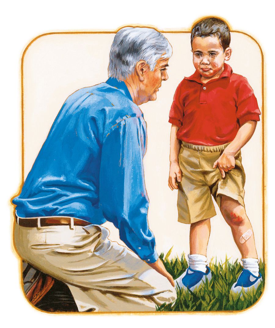 Um homem consola um menino que se magoou no joelho