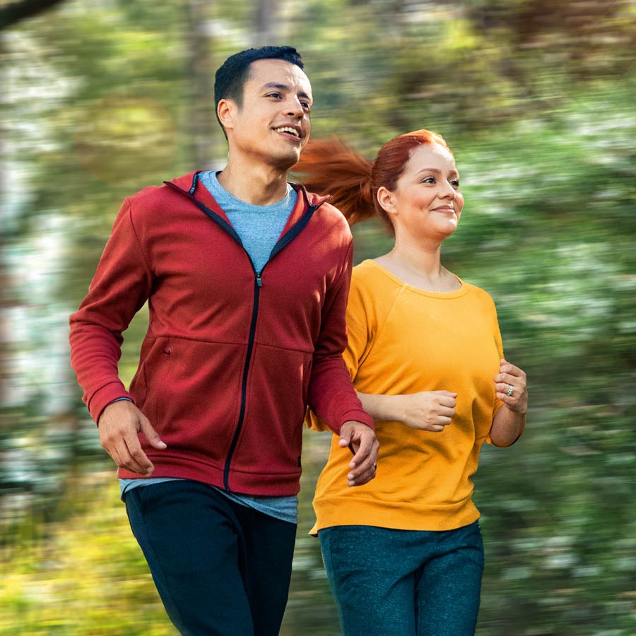 Um casal faz exercício no bosque.