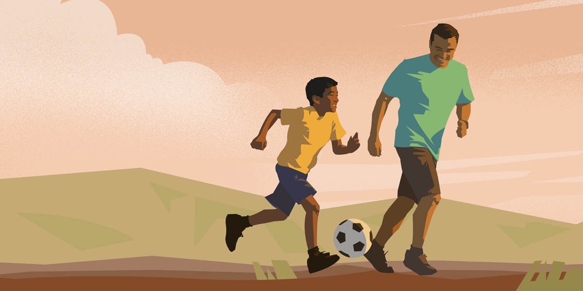 Um homem joga futebol com seu filho