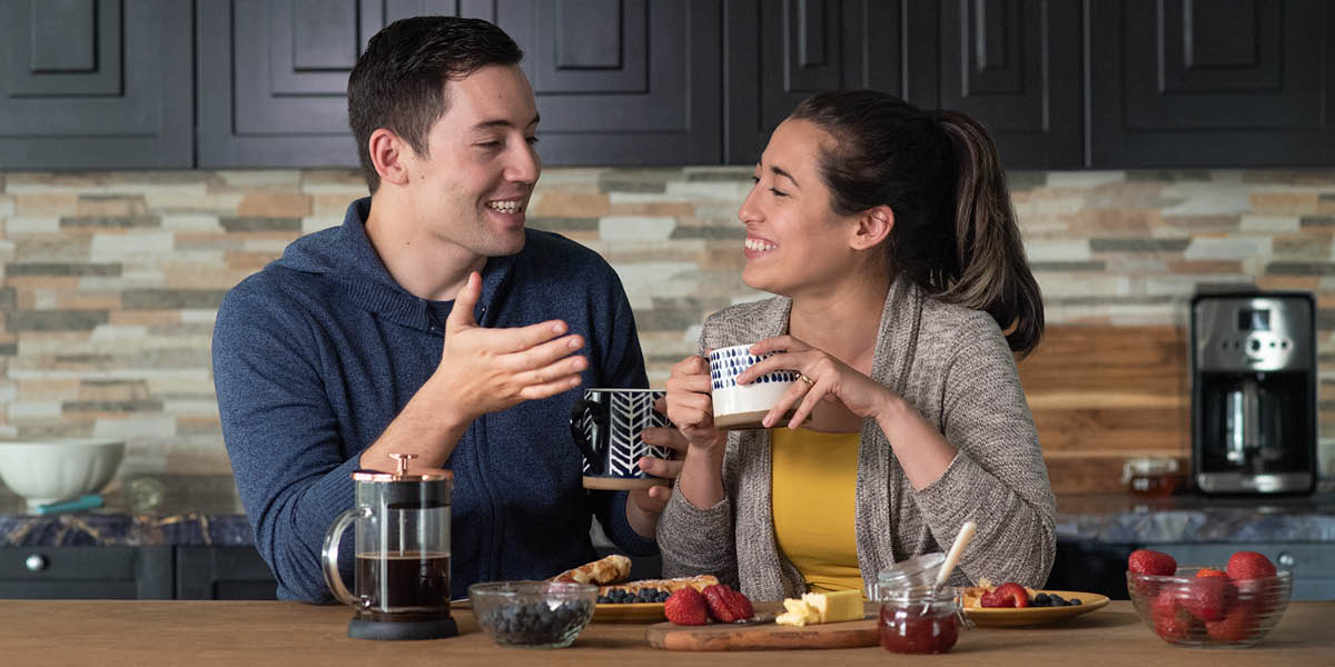 Um casal feliz tomando café da manhã junto.
