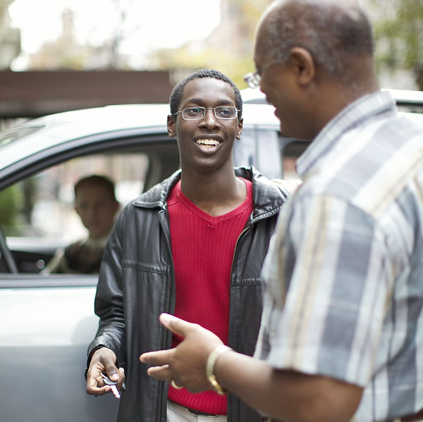 Pai dando a chave do carro para filho adolescente