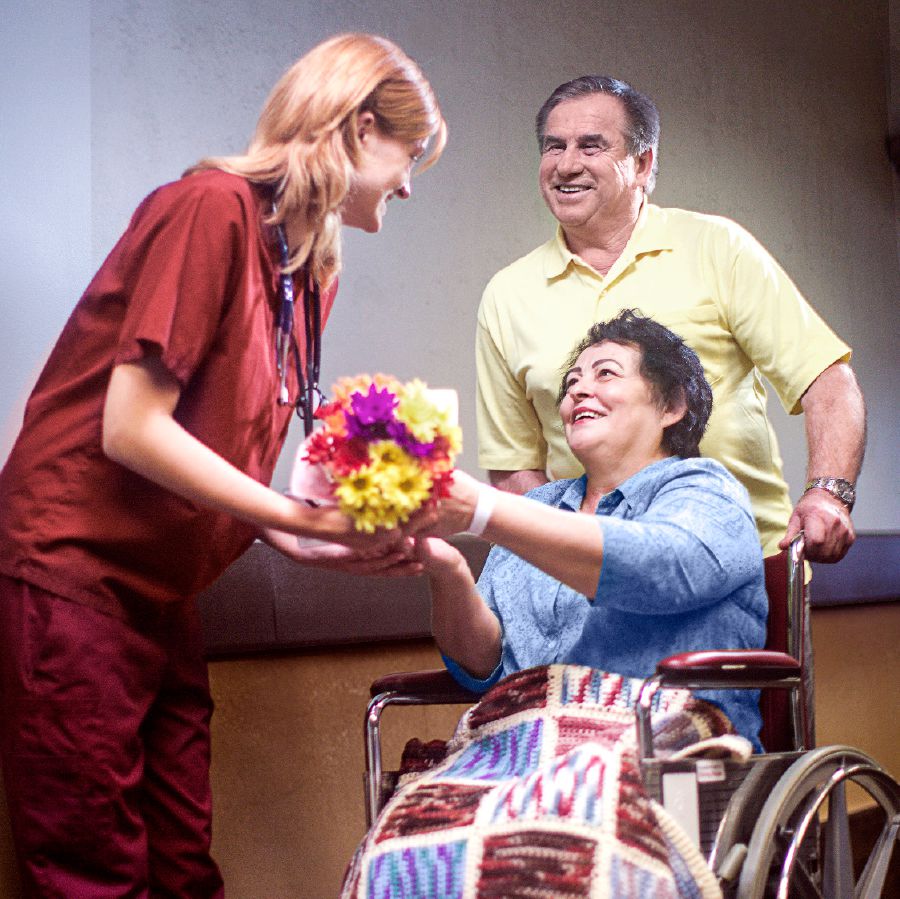 Um casal dá flores para uma enfermeira
