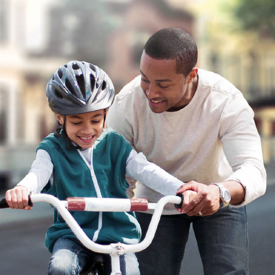 Um pai ensinando o filho a andar de bicicleta