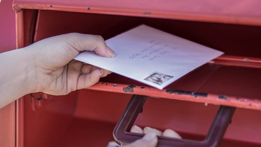 Uma irmã colocando uma carta na caixa de correio