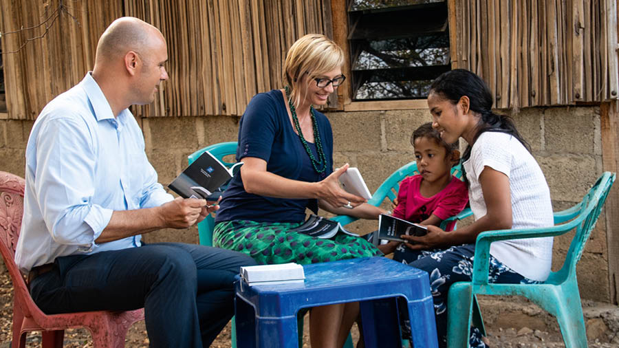 Vanessa e Alex dirigindo um estudo da Bíblia ao ar livre para uma mãe e sua filha.