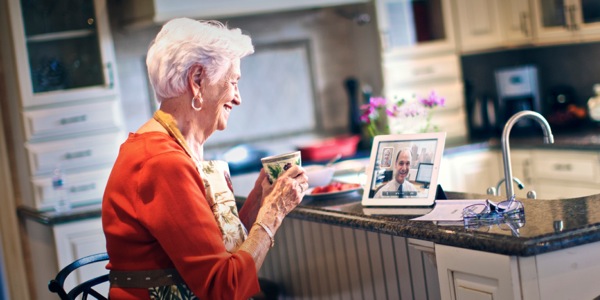 Um filho conversando com sua mãe idosa pelo computador