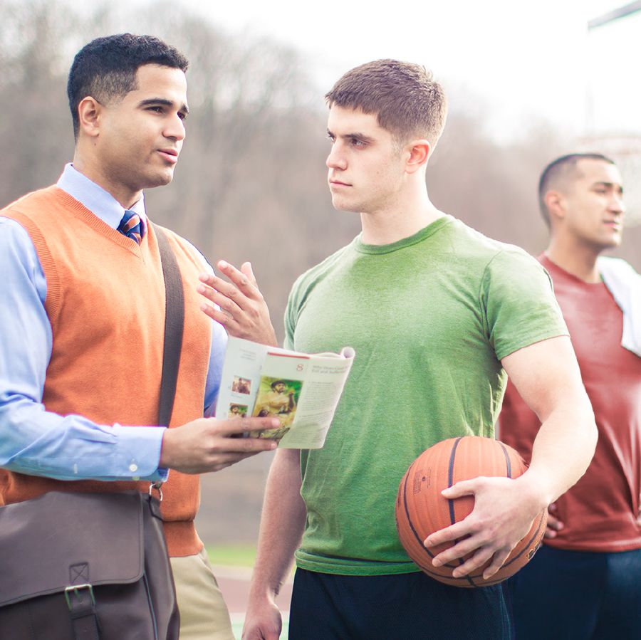 Um irmão pregando para um jovem que estava jogando basquete