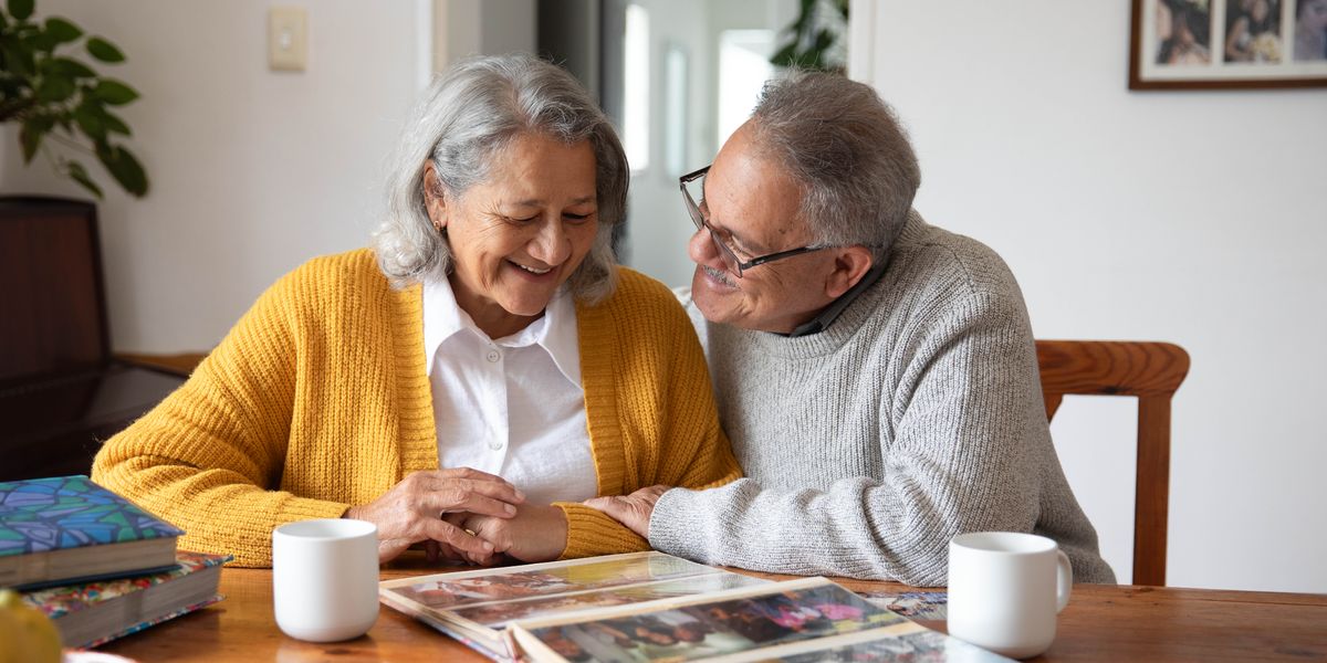 Un matrimonio mayor muy feliz mirando un álbum de fotos.