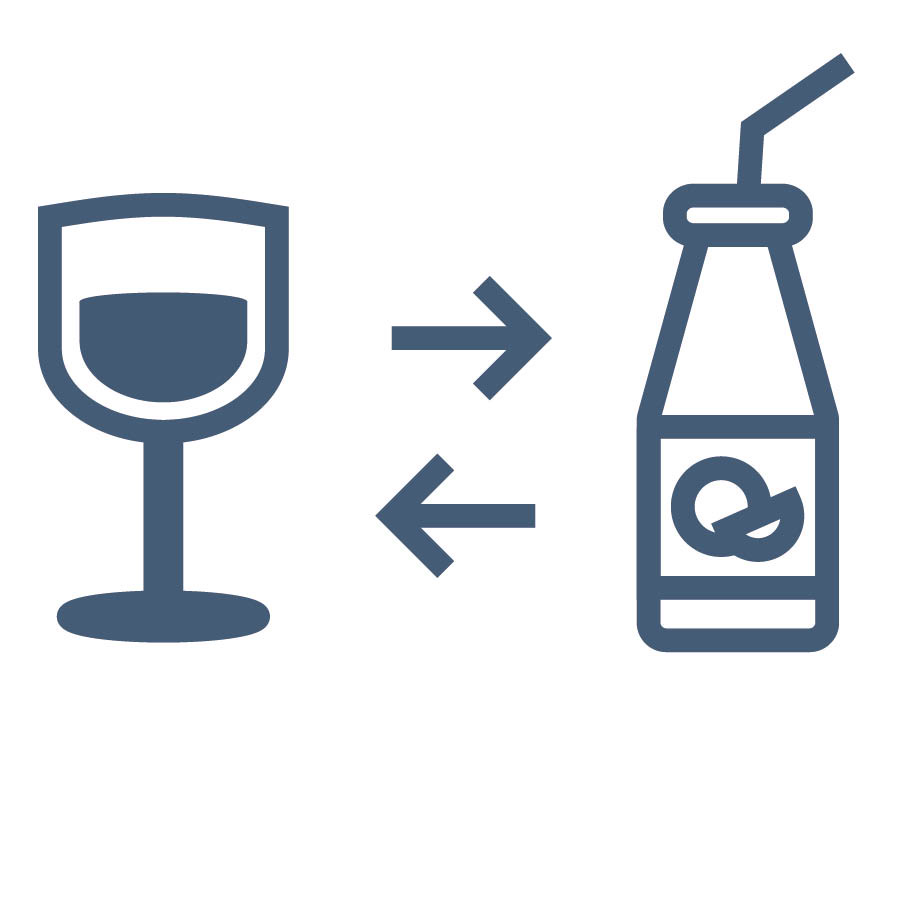 Una copa de vino junto a una botella de jugo de fruta.