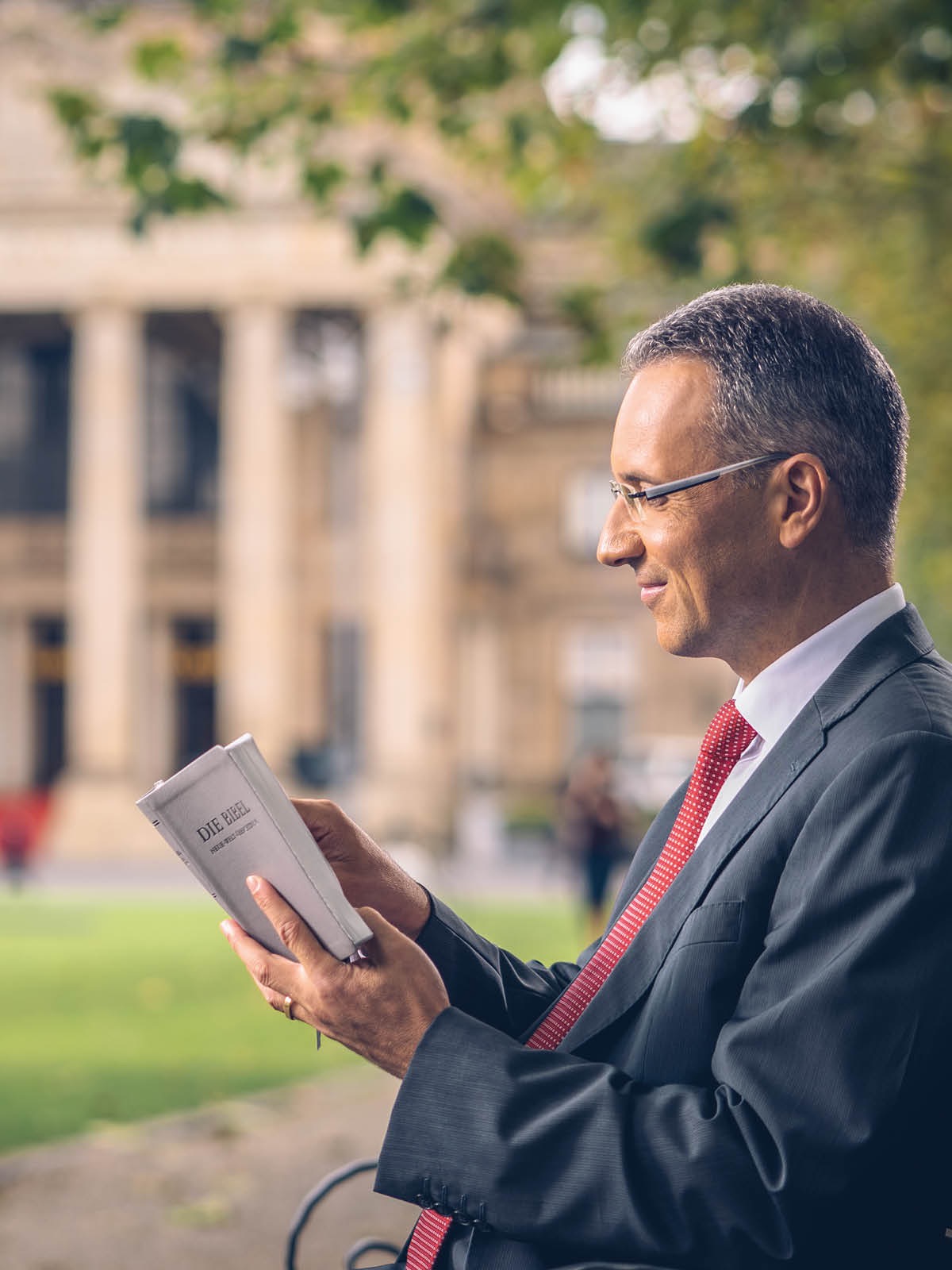 Iech murș beșel pi banca angla iech clădirea le guvernoschi hai citil i Biblia.