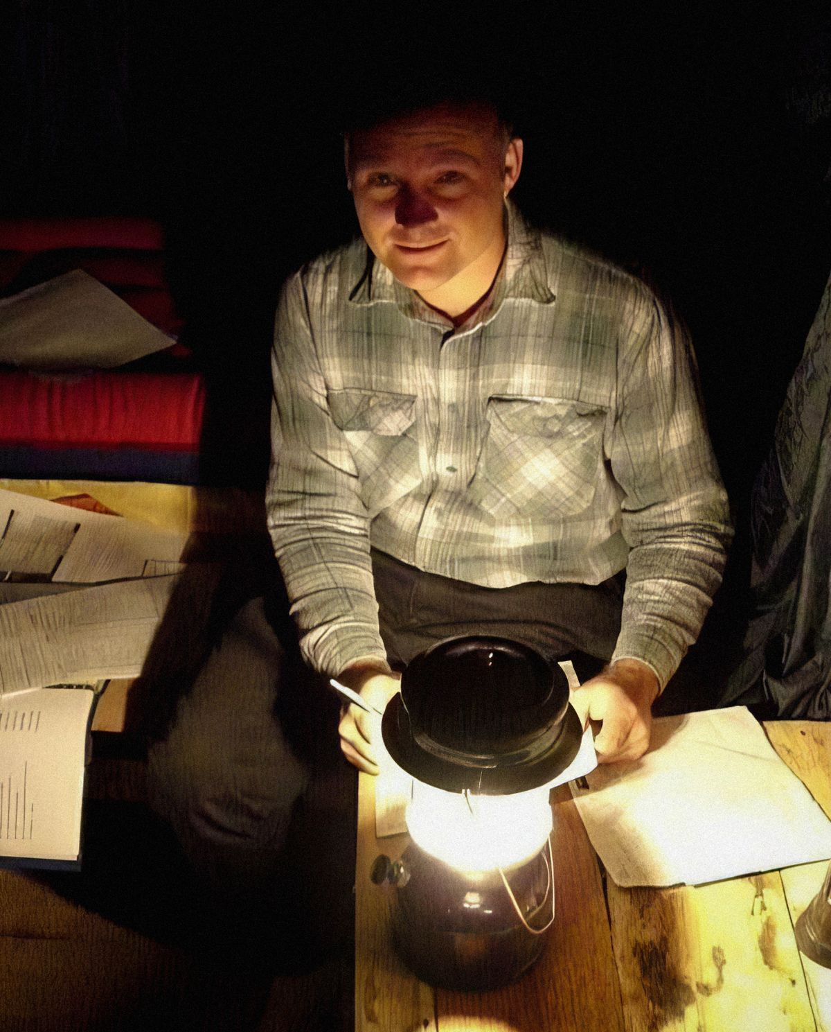 Warren pregătind rapoarte la lumina unei lămpi