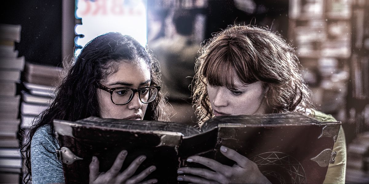 Две девушки читают старинную книгу по магии