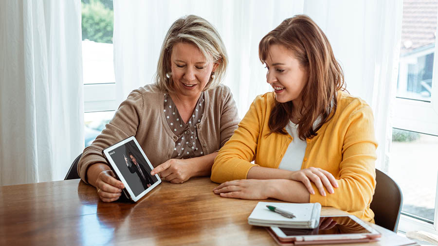 Сестра показывает женщине, с которой изучает Библию, видеоролик.