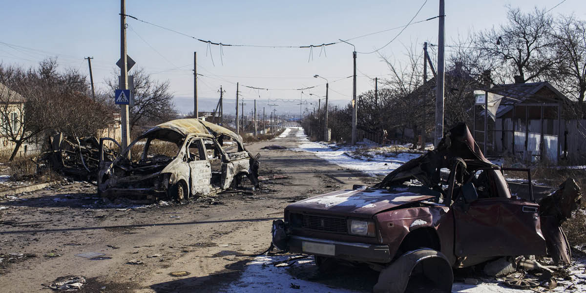cnt_01: Искорёженные взрывами автомобили на сельской улице в Украине.