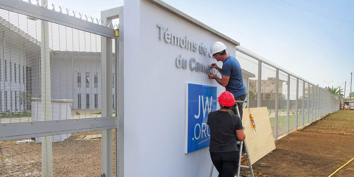 Trabalhadores instalando o novo letreiro na filial de Camarões.