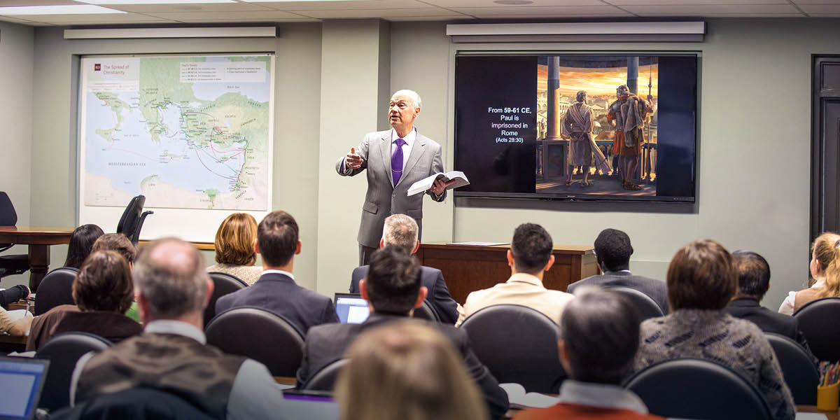 Irmão Stephen Lett do Corpo Governante falando com os alunos de Gileade numa sala de aula.