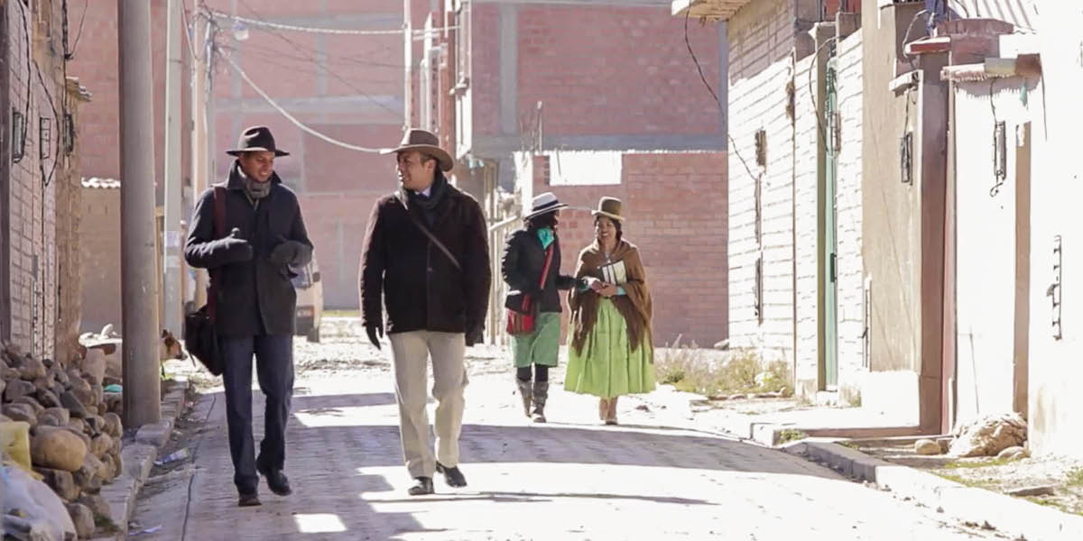 Um casal de missionários prega de casa em casa com outro casal.