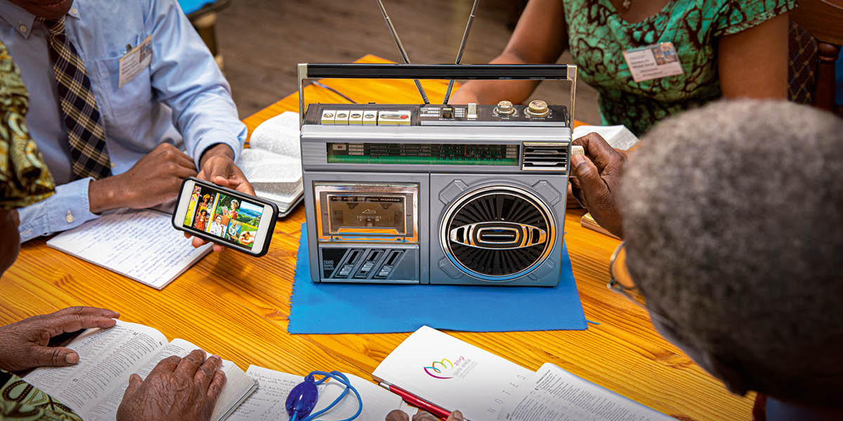 Irmãos ouvindo a transmissão do congresso pelo rádio.