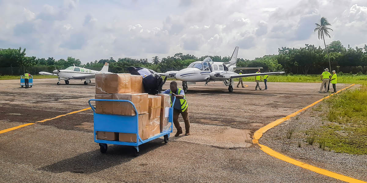 Suprimentos de ajuda humanitária sendo retirados de dois aviões.