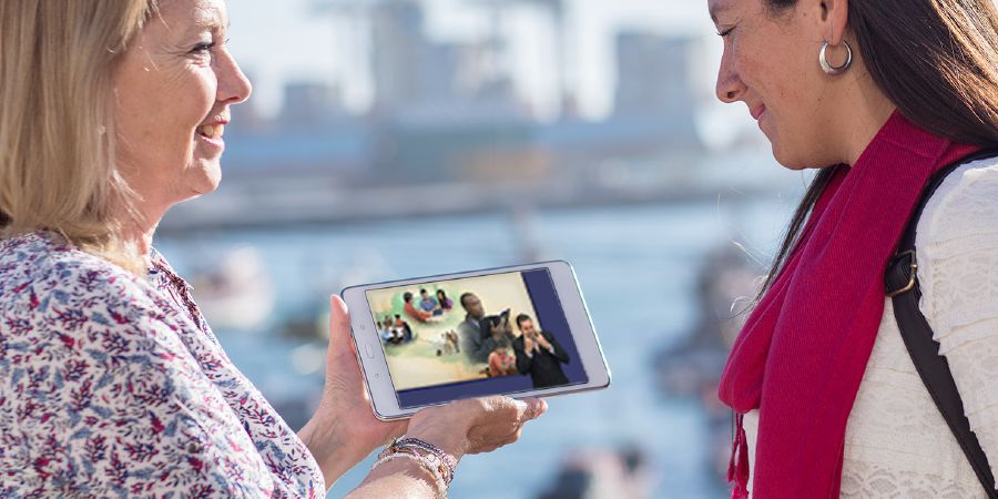 Uma irmã mostrando para uma mulher o vídeo Por Que Estudar a Bíblia?