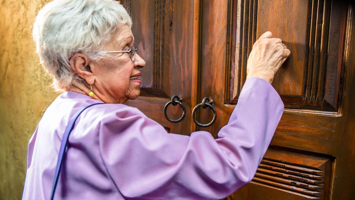 En prédication, une sœur âgée frappe à une porte.