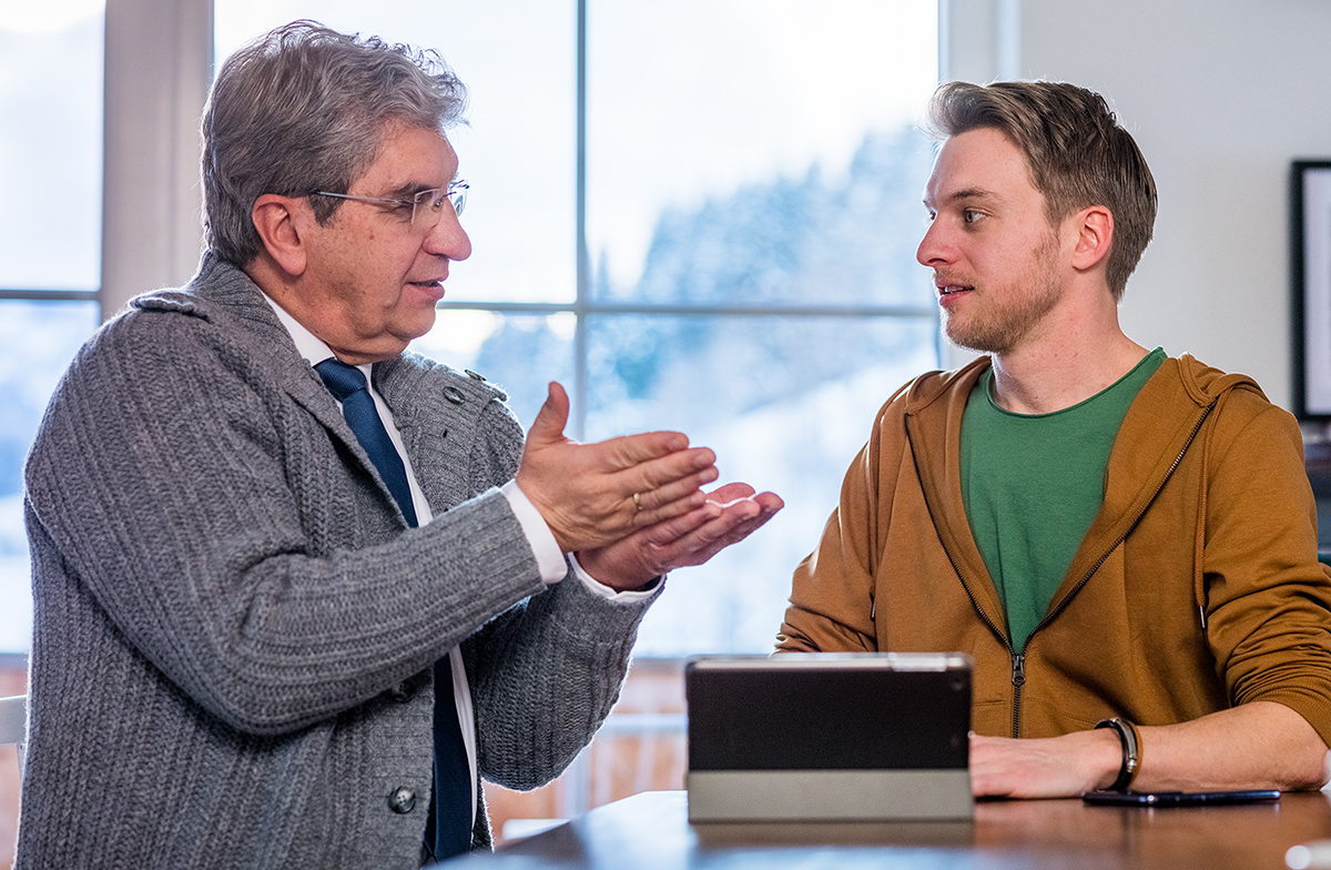 M’bale akuonetsa wophunzira wake vidiyo pogwiritsa ntchito foni.