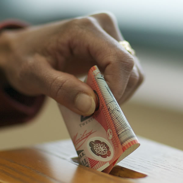 Vkladanie peňazí do schránky na dary