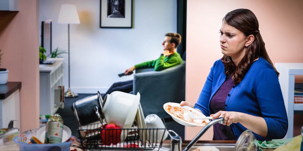 Manželka je nahnevaná, lebo jej manžel pozerá televíziu a nepomôže jej s riadmi