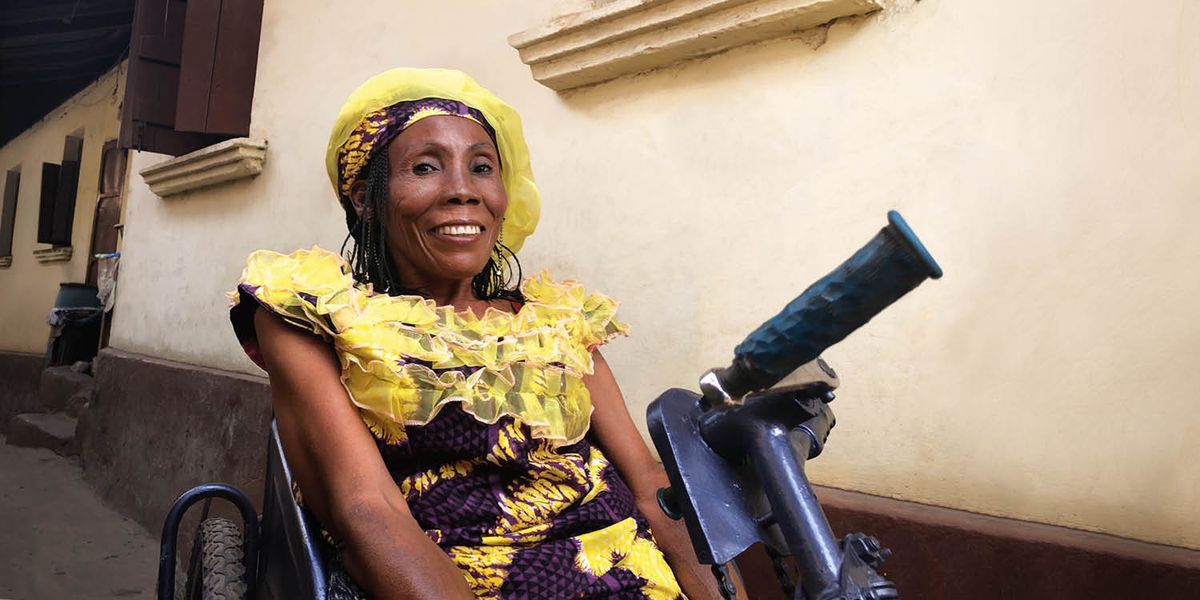 Jay Campbellová s úsmevom na tvári sedí na svojom trojkolesovom vozíku na ručný pohon