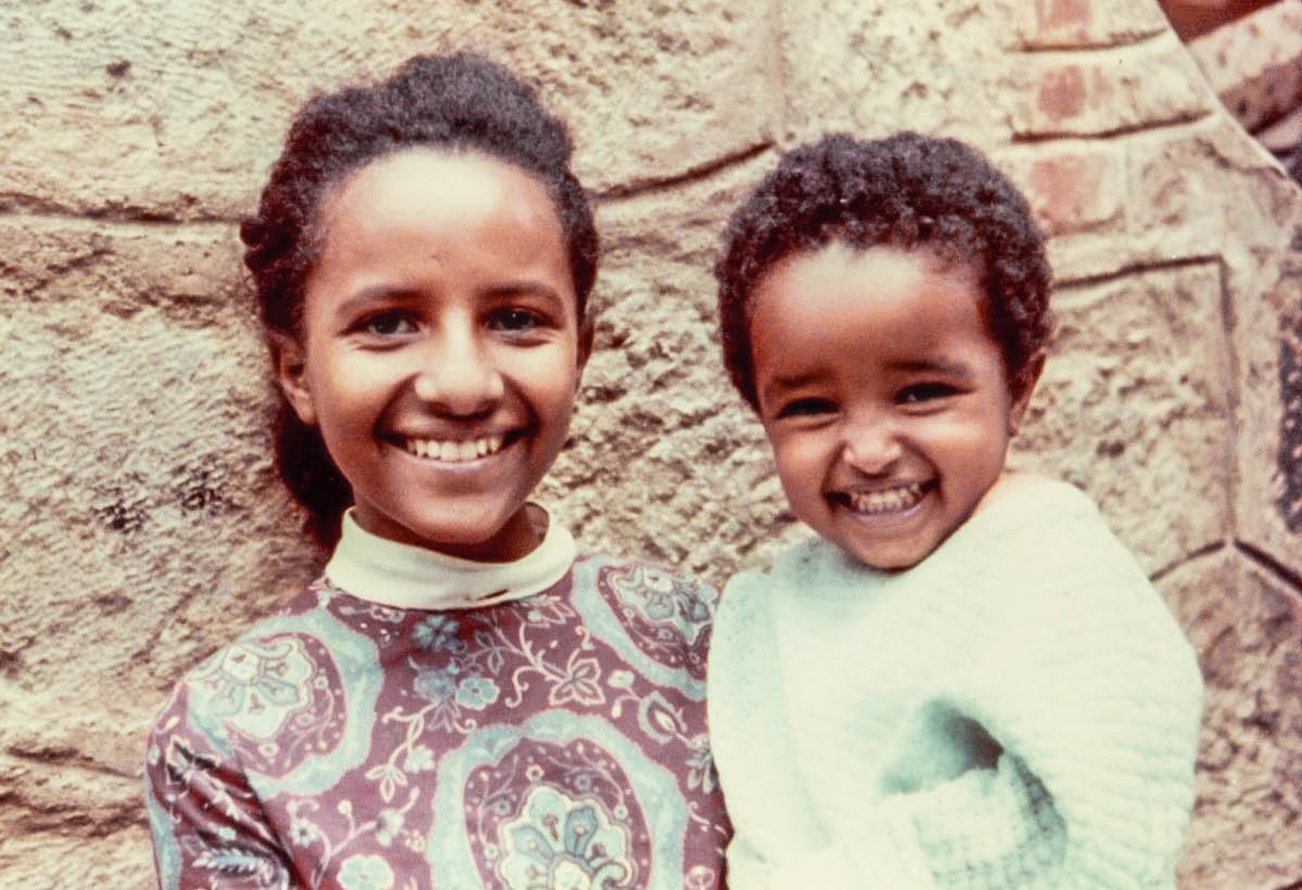 Aster ako mladé dievča drží na rukách svojho malého brata Josiaha