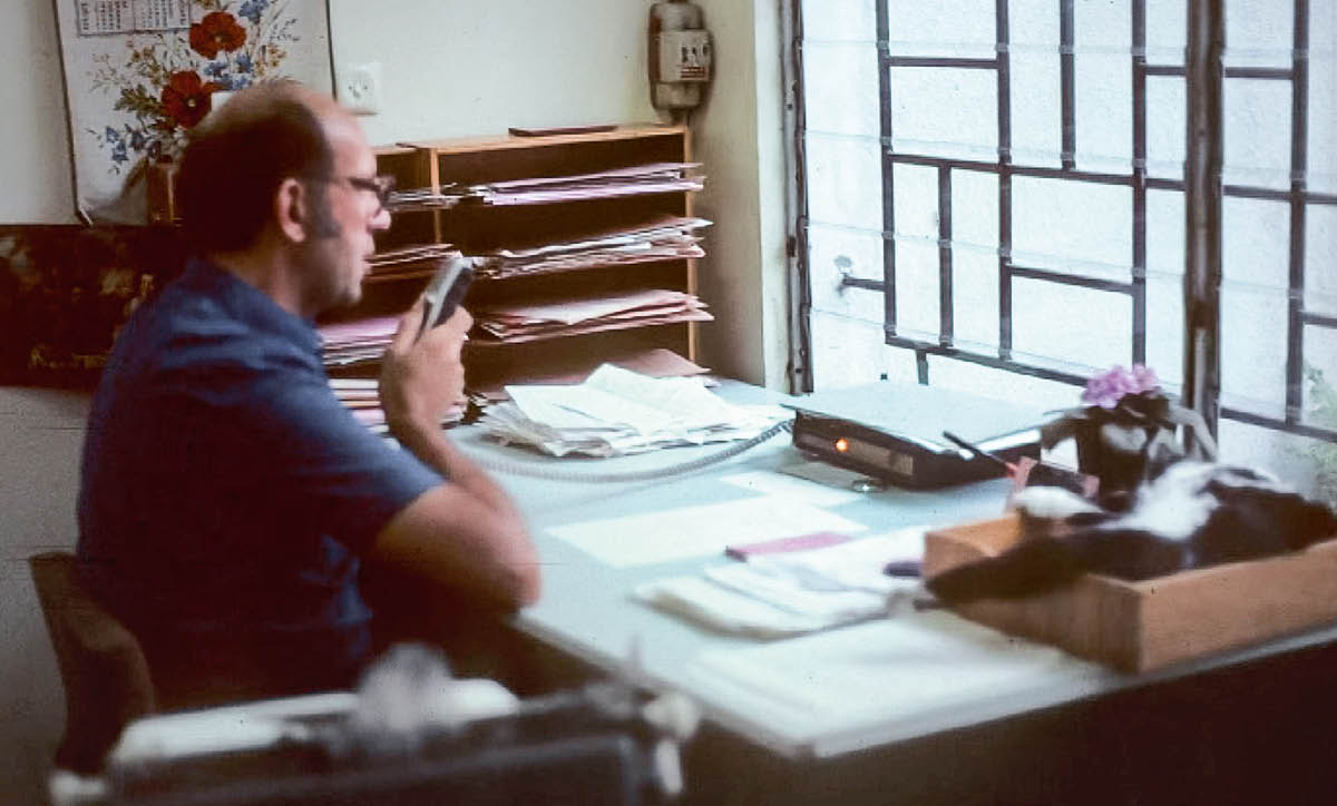 Dayrell vo svojej kancelárii hovorí do diktafónu