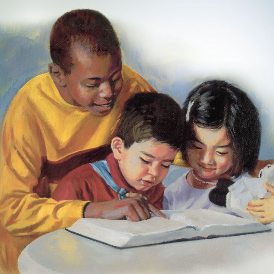 Chlapec číta Bibliu dvom malým deťom