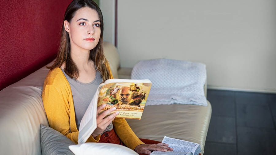 Sestra rozjíma o tom, čo si práve prečítala v Biblii, a používa pri tom knihu Dôkladne svedč o Božom Kráľovstve