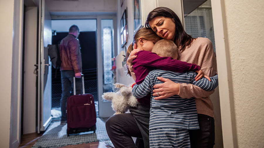 Otec ťahá kufor a odchádza z domu; mama objíma svoje dve plačúce deti