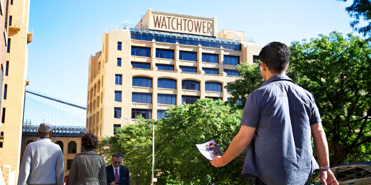 Muž s pozvánkou na dni otvorených dverí prichádza na Columbia Heights 25, Brooklyn, New York