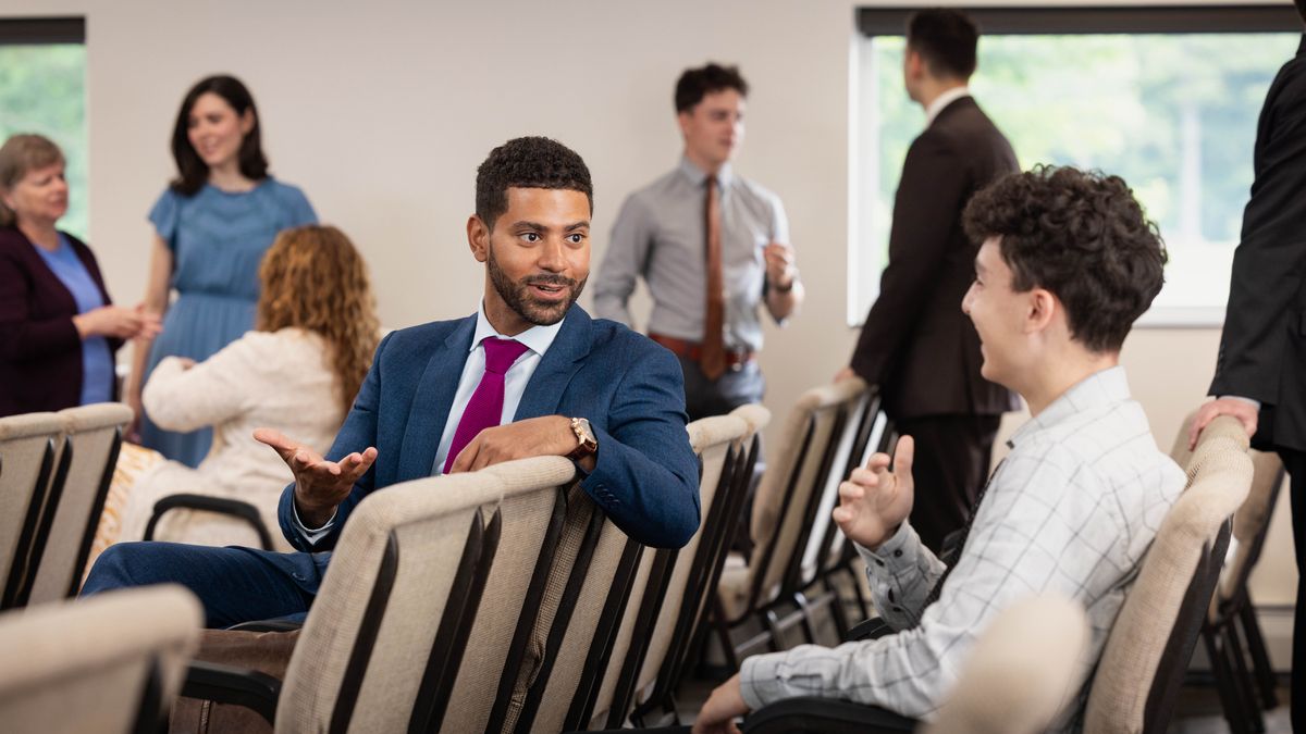 Брат након састанка седа поред тог младића. Обојица су насмејани и уживају у разговору.