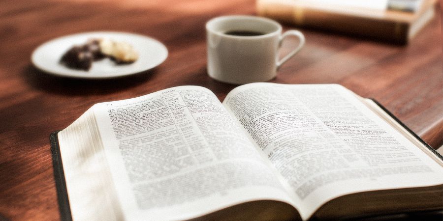 Biblia iliyofunguliwa na kikombe kiko kando yake
