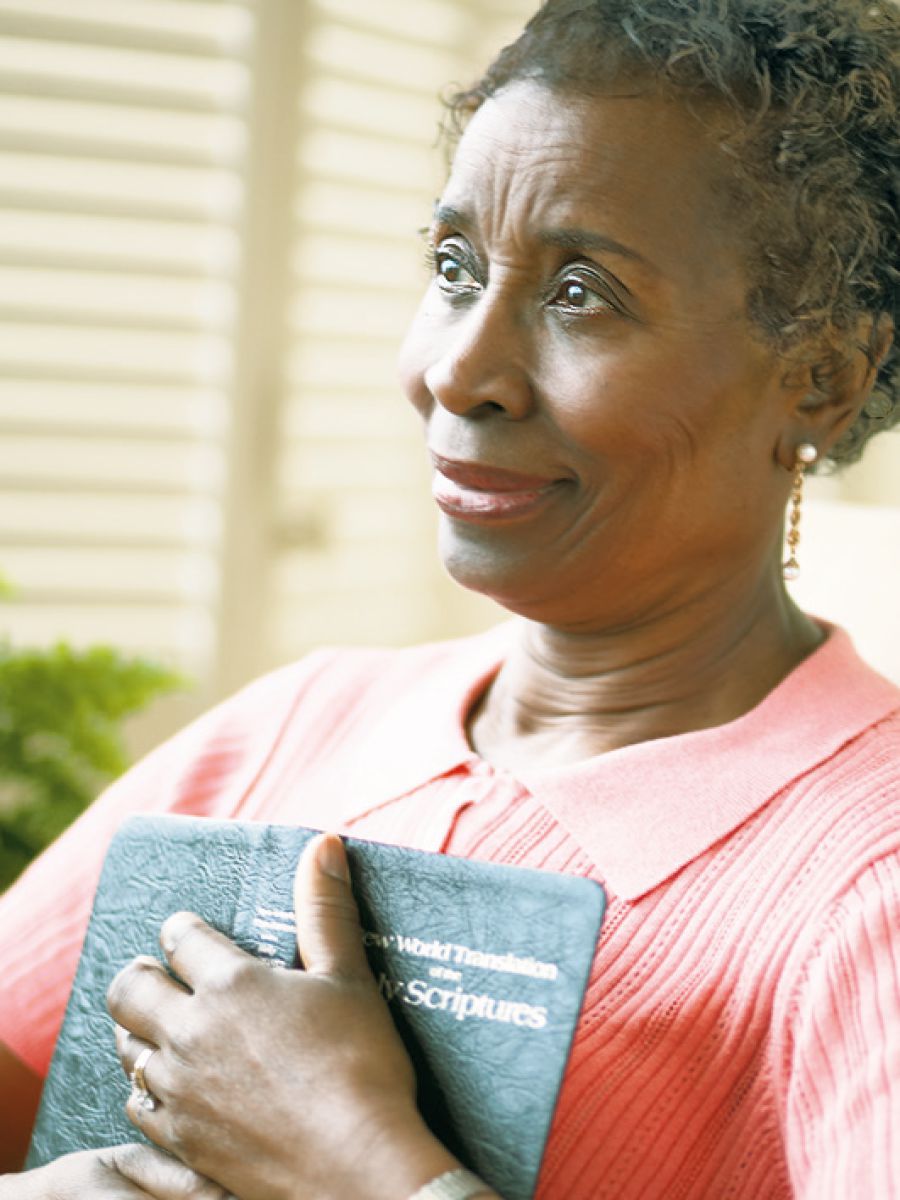 Mwanamke akiwa ameikumbatia Biblia huku akitabasamu