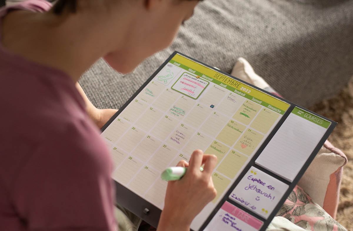 Joven feto ida hakerek ninia oráriu lee Bíblia nian iha kalendáriu.