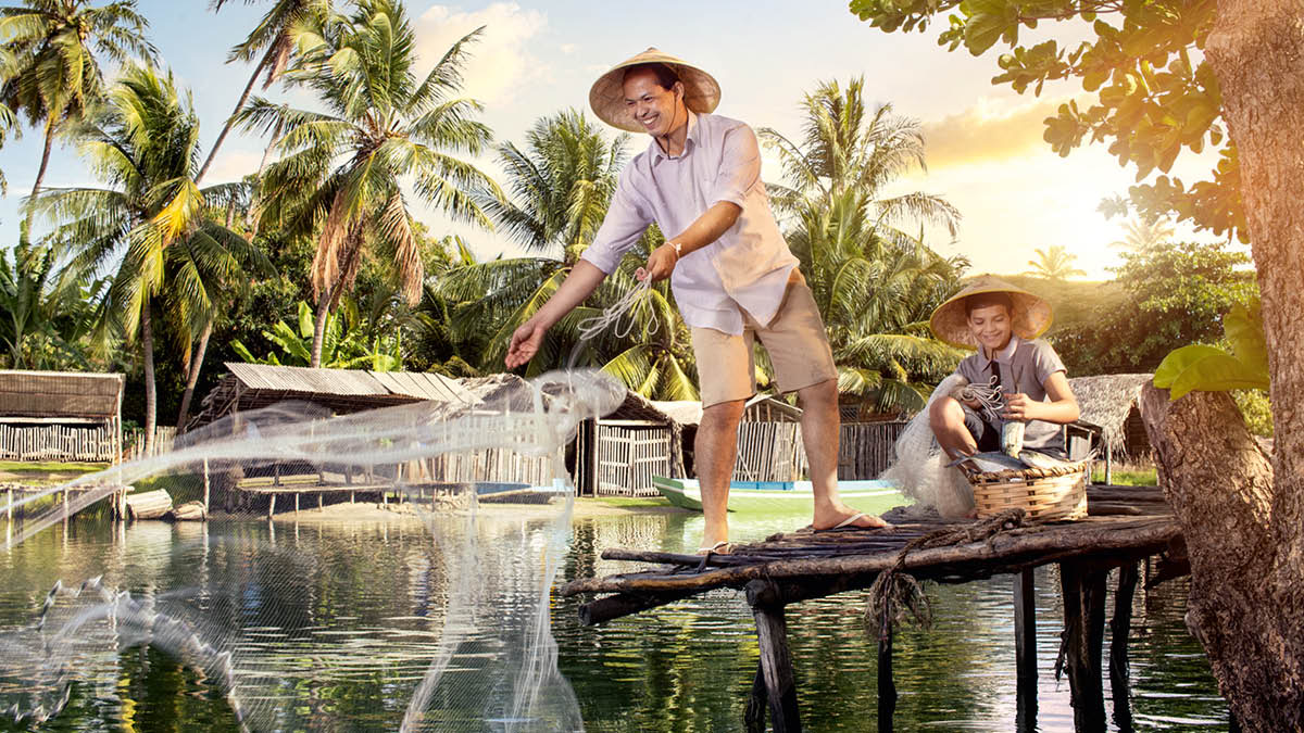 ሓደ ሓው ምስ ወዱ ዀይኑ ዓሳ ንምግፋፍ መርበብ ይድርቢ።