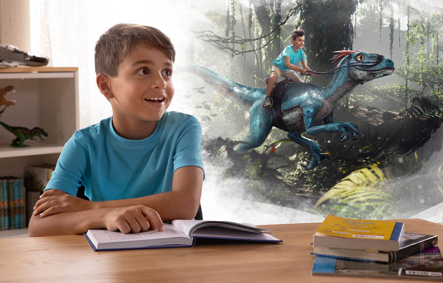Bir erkek çocuk kitap okuyor ve kendini bir dinazora binerken hayal ediyor.