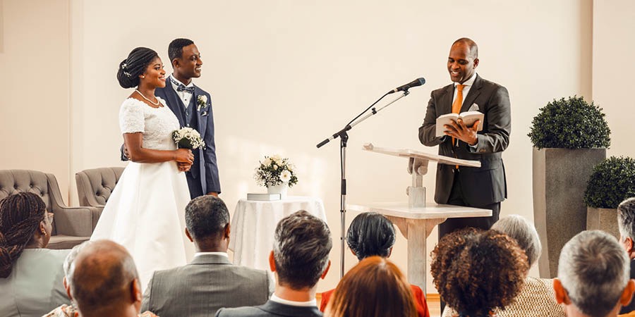 A bride and groom getting married in a Kingdom Hall. A minister of Jehovah’s Witnesses gives a Bible-based wedding talk.