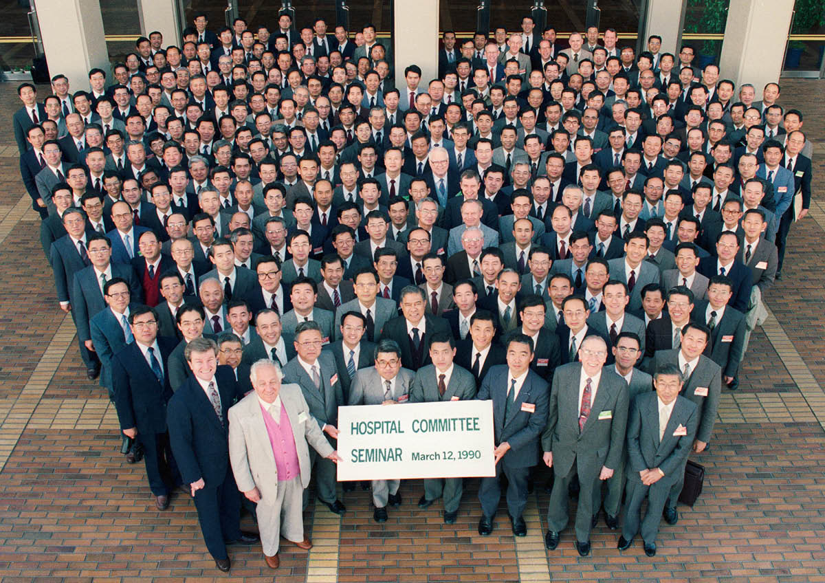 Eugene na kagulu ka ŵabali ŵachoko waka ŵali pa Ungano mu Komiti Yakudumbirana na Chipatala pa March 12, 1990, ku Japan.